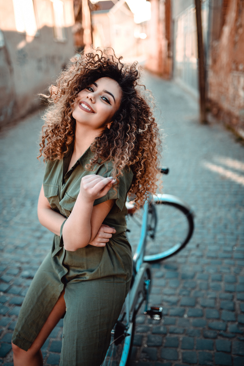 Cute Curly Hair Female Sitting On Bicycle