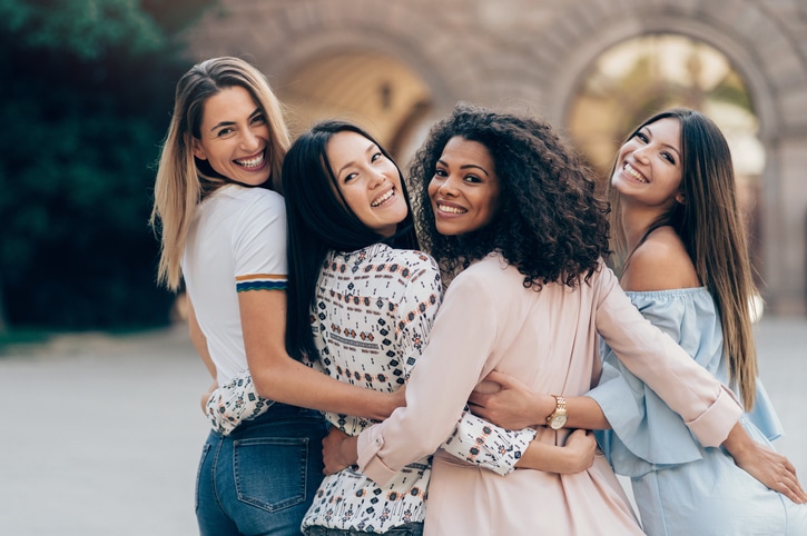 female friends looking back and smiling towards the camera