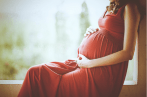 Pregnant woman touching her belly with hands