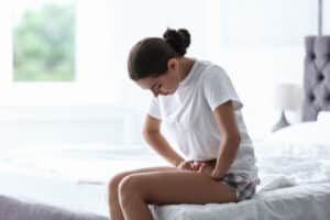 Young,Woman,Suffering,From,Menstrual,Cramps,At,Home.,Gynecology