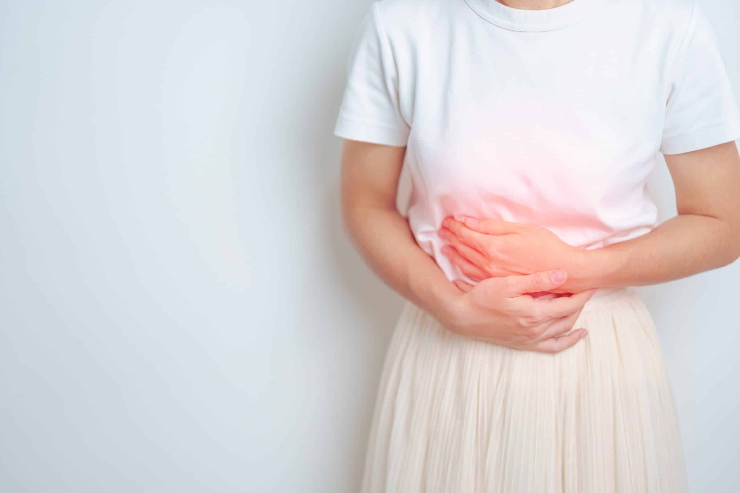 A cropped shot of a woman holding her abdomen, experiencing pain that could be managed with a hysterectomy