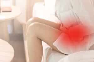 A woman with ovarian cysts holding her abdomen in pain