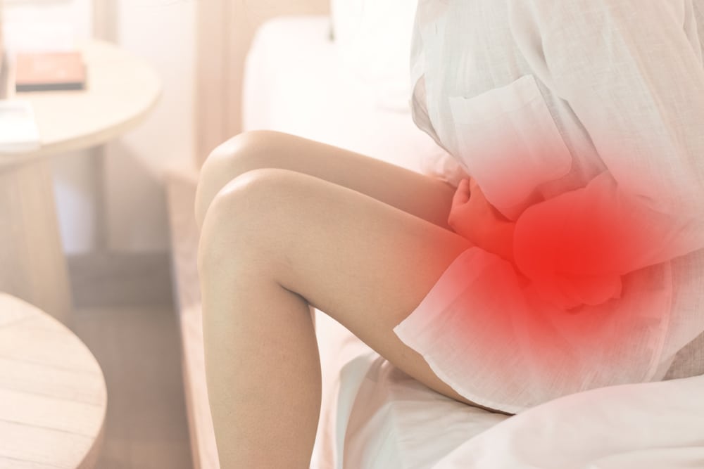 A woman with ovarian cysts holding her abdomen in pain