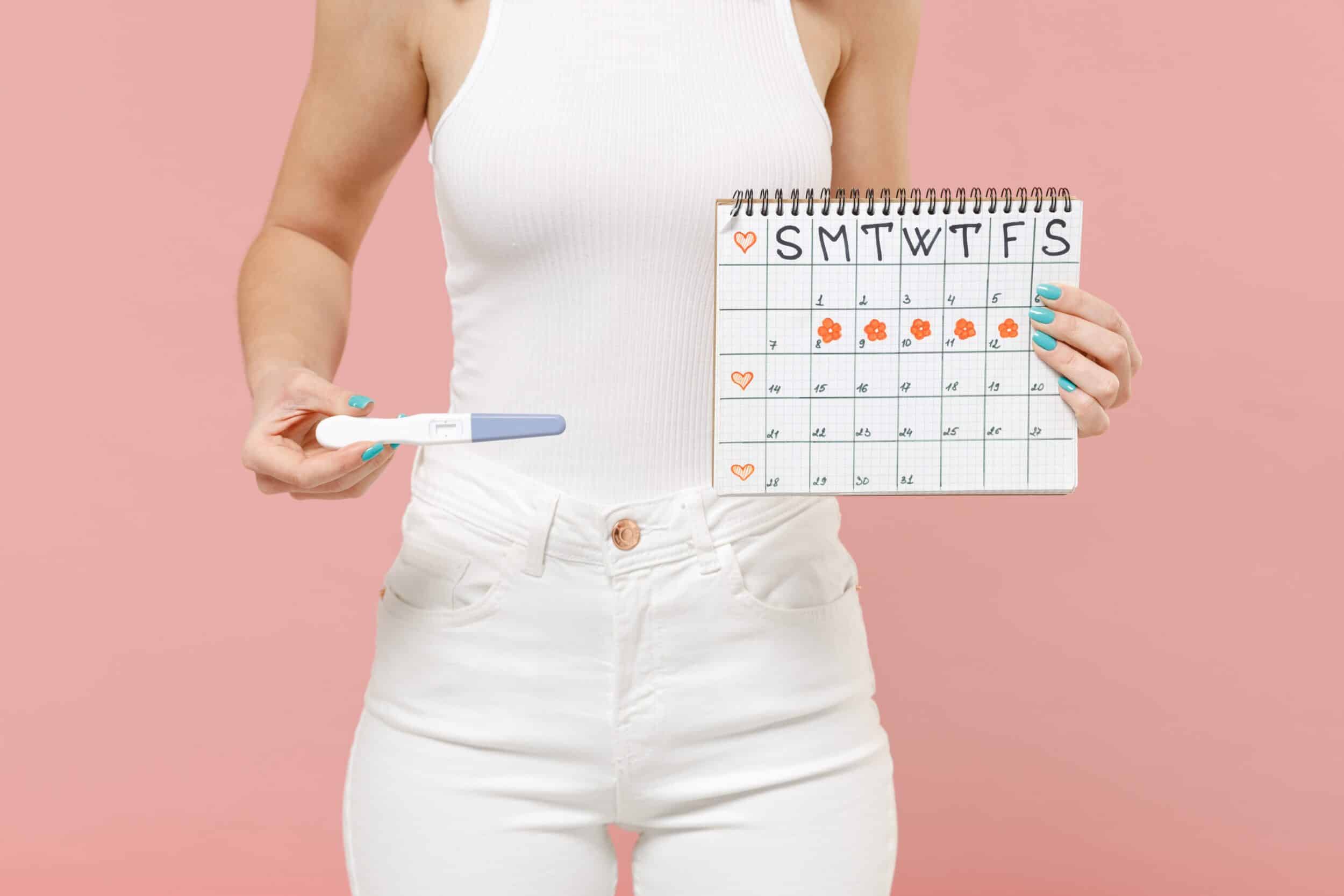 A woman holding a calendar to track vaginal discharge throughout the menstrual cycle