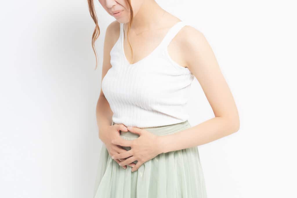 A woman with uterine fibroids holding her stomach