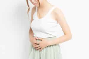 A woman with uterine fibroids holding her stomach