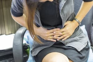 A cropped shot of a woman with pelvic pain in Houston holding her stomach