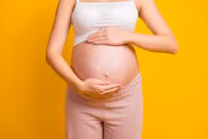 A cropped shot of a woman with pelvic pain in Houston holding her stomach 5 Common Factors That Make a Pregnancy High-Risk
