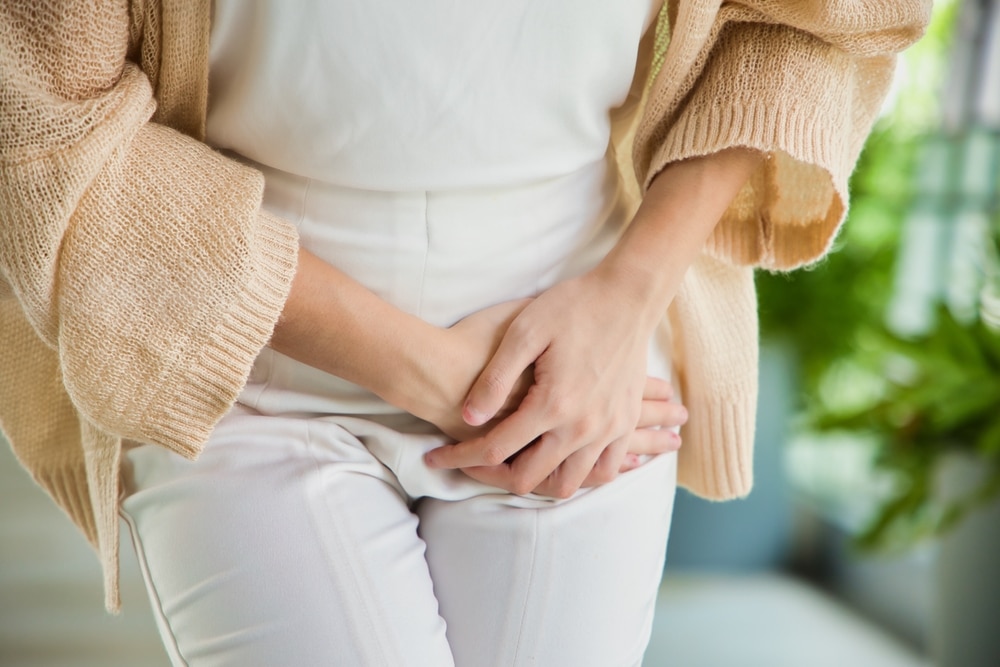 A close-up shot of a woman with urinary incontinence crossing her legs