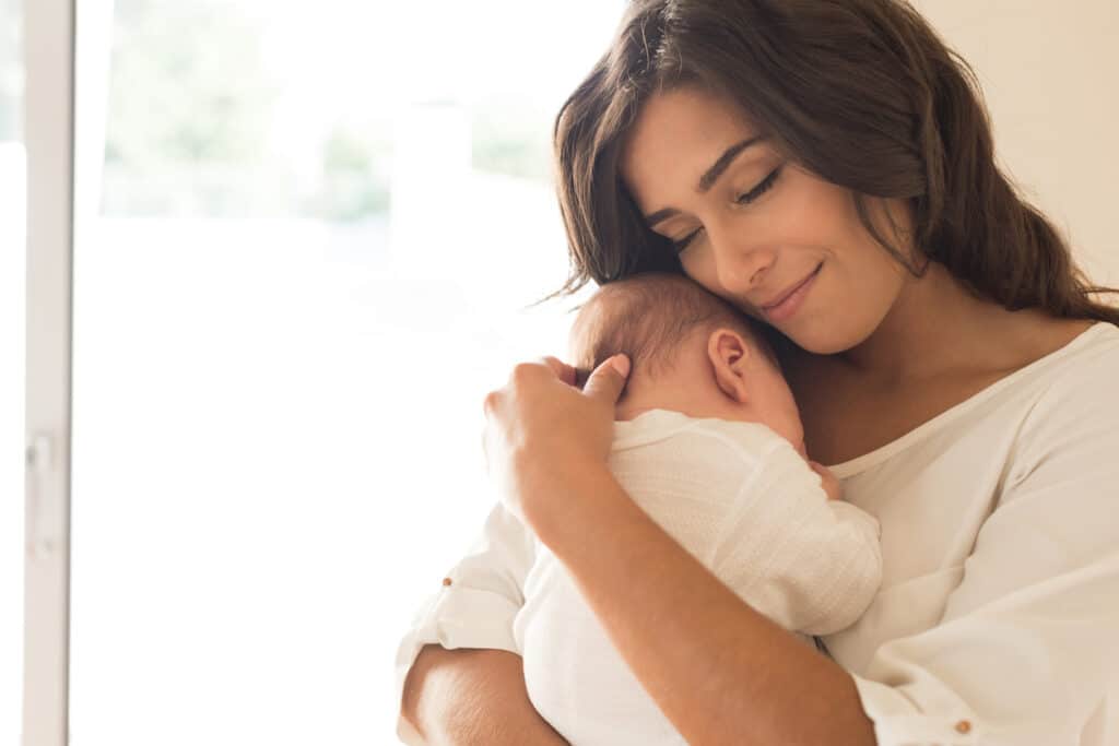 Woman holding her baby during six-week postpartum visit in Houston